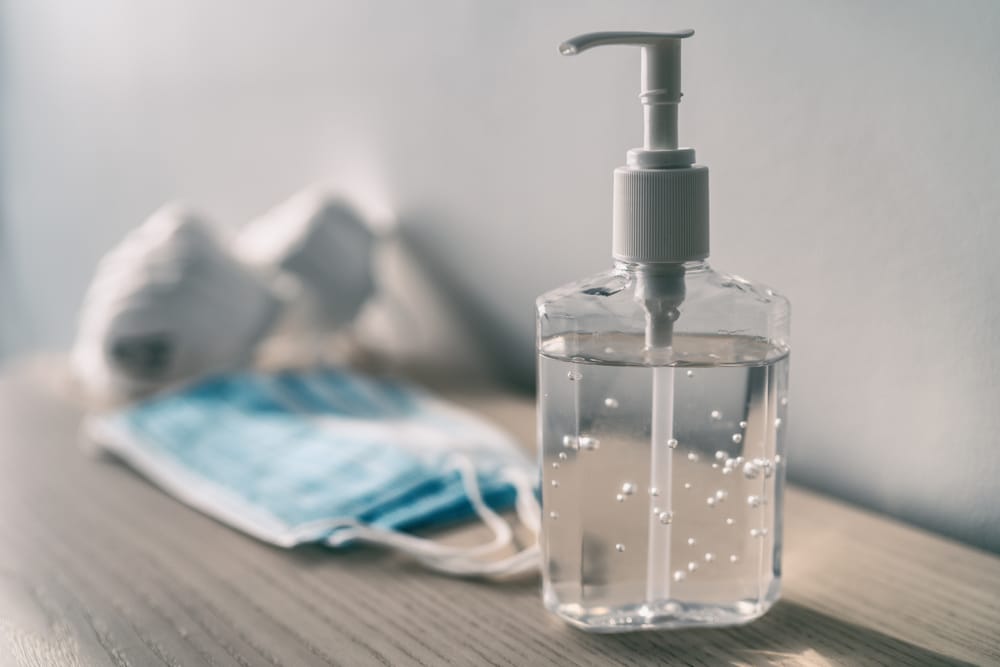 A closeup of a bottle of hand sanitizer sitting on a dresser.