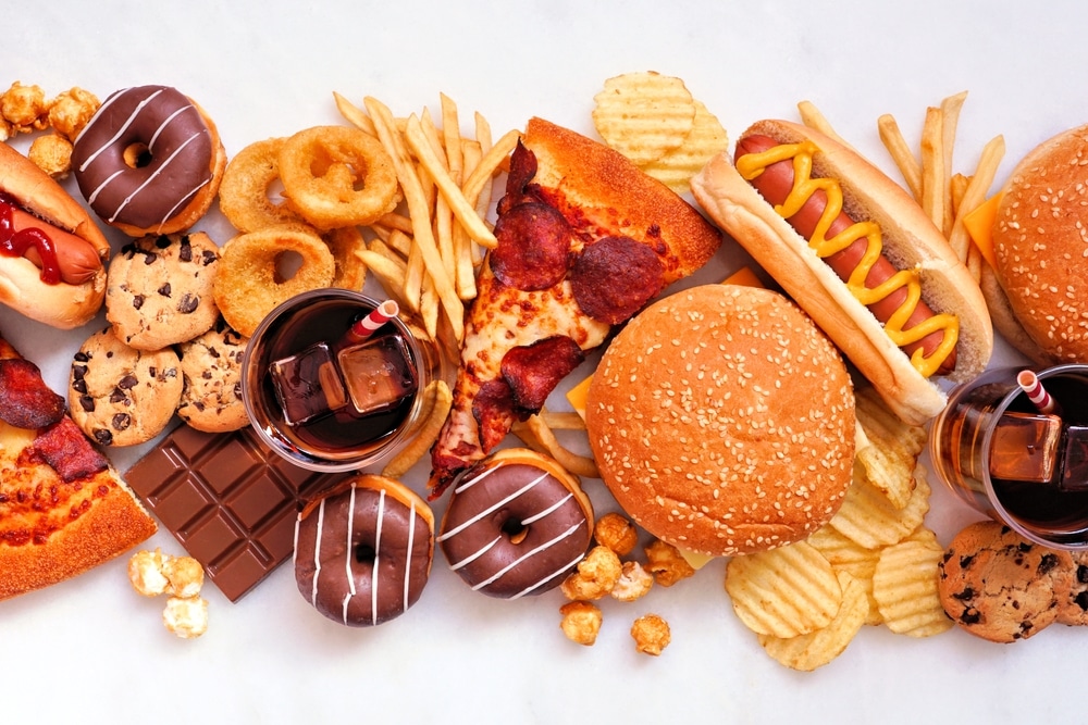 An array of junk food, such as pizza, donuts, and cookies.