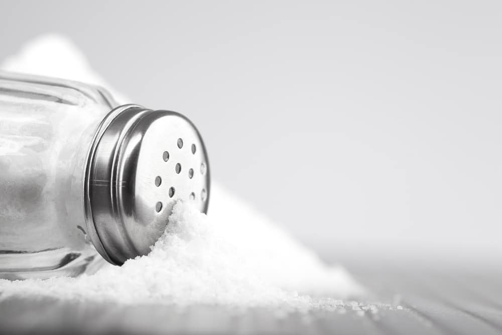 A closeup of a spilled container of salt.