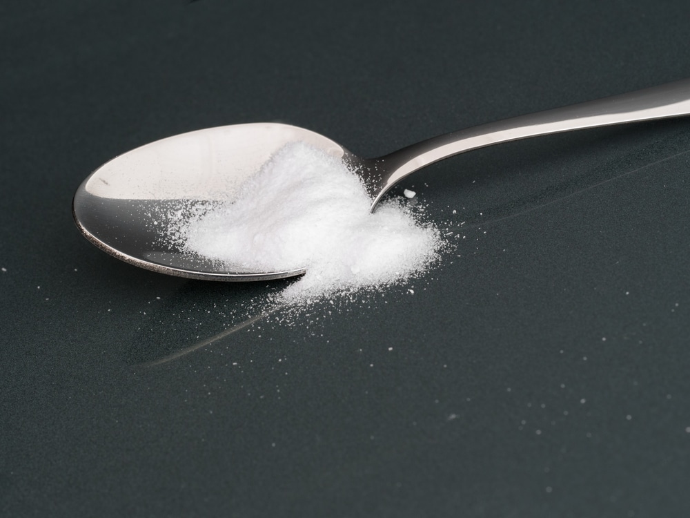 Saccharin both in and spilled out of a spoon.